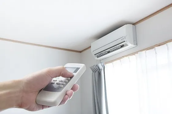 D&L Plumbing Heating Air Conditioning wall unit and hand using remote control D&L Plumbing Heating Air Conditioning wall unit and hand using remote control